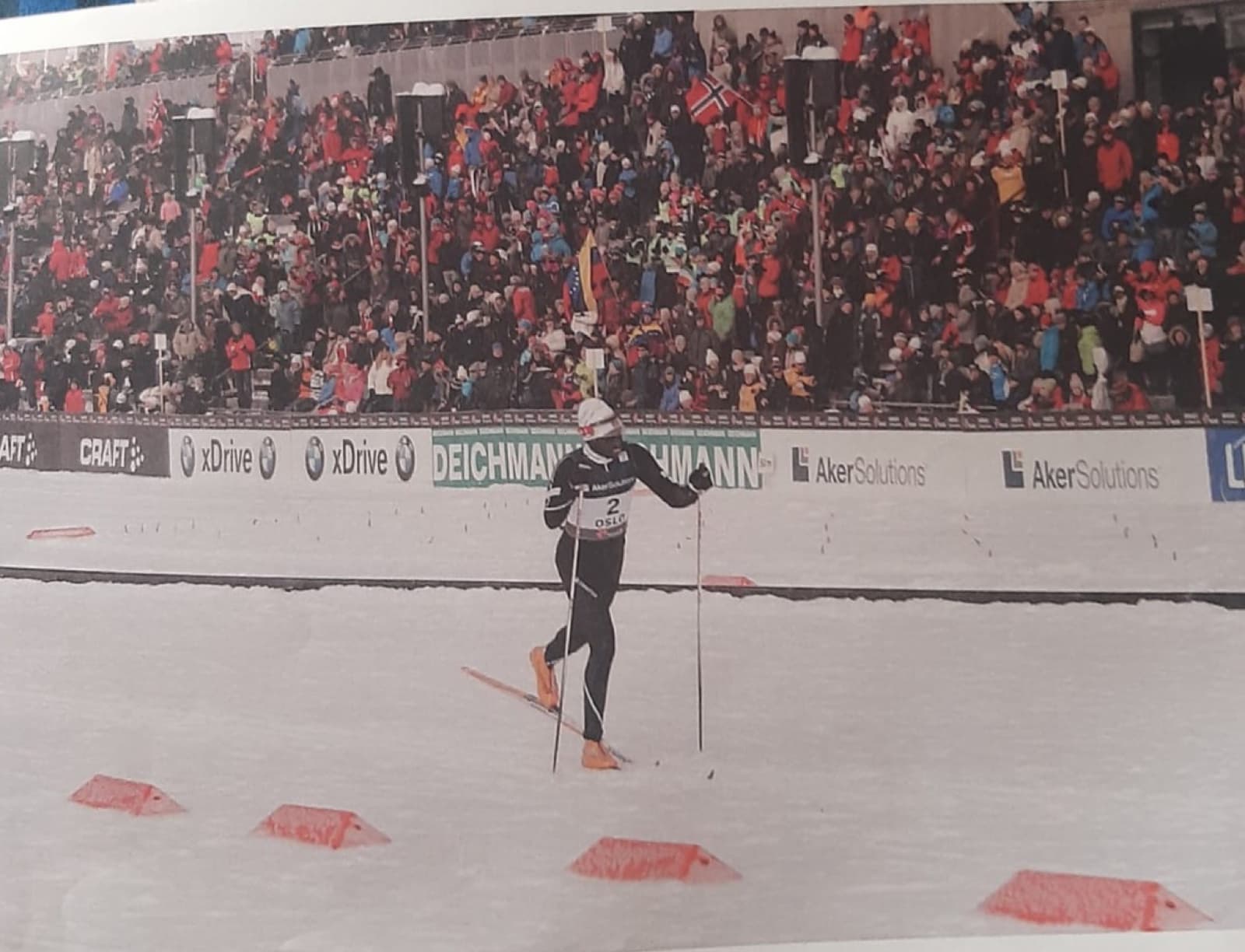 Philip Boit racing cross-country before a packed grandstand